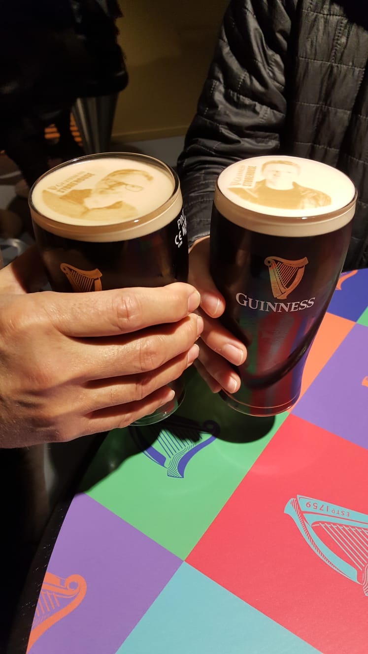 Two pints clinked together over a pub table